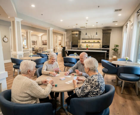 Group of Seniors Playing Cards in Common Room at Assisted Living Facility Group of Seniors Playing Cards in Common Room at Assisted Living Facility