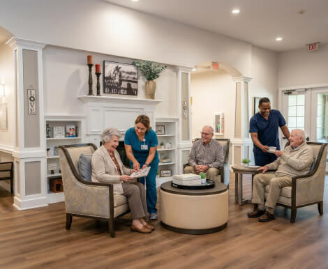 Nursing Staff Assisting Elderly Residents in Common Room at Assisted Living Facility Nursing Staff Assisting Elderly Residents in Common Room at Assisted Living Facility